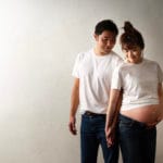 妊婦と夫が手を繋いでいるマタニティフォト
