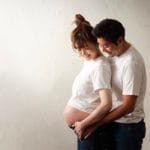 妊婦を後ろから抱きしめる夫