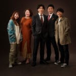 ブラウンのスクリーンで家族５人立ち全身